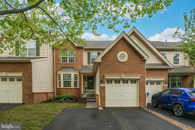 townhome / multi-family property with brick siding, an attached garage, roof with shingles, and aphalt driveway