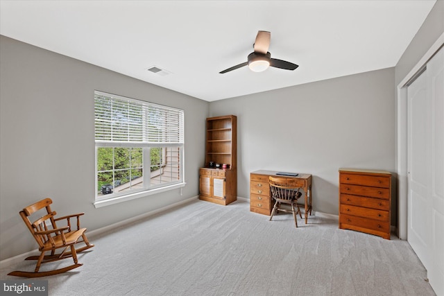 carpeted office space featuring baseboards, a ceiling fan, and visible vents