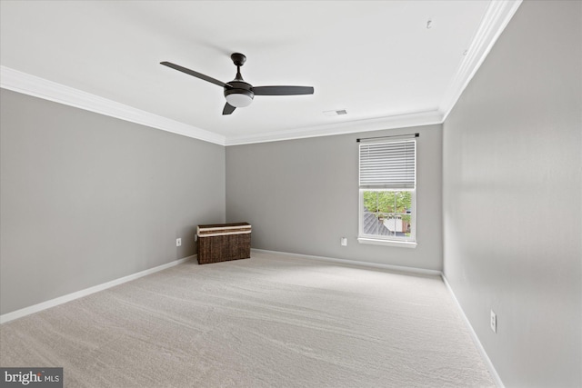 carpeted spare room with baseboards, ornamental molding, and ceiling fan