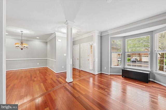 entrance foyer with baseboards, decorative columns, a wealth of natural light, and hardwood / wood-style floors