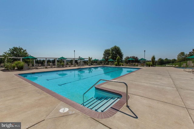 pool featuring fence and a patio area