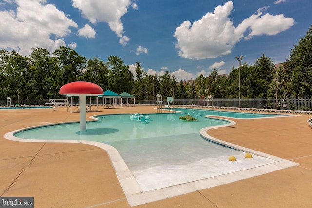 pool featuring fence and a patio area