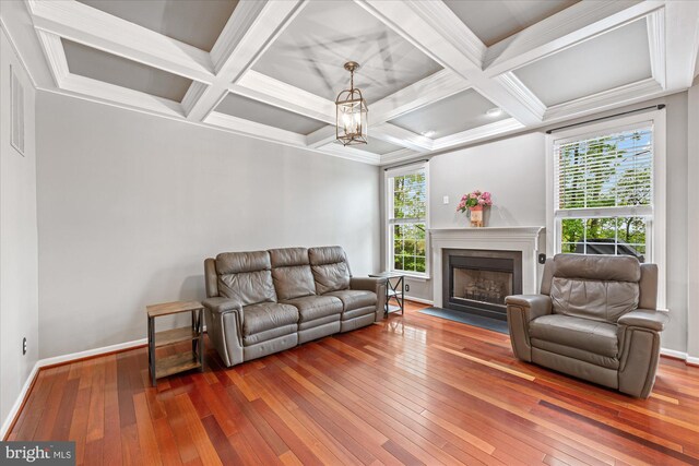 living room with baseboards, a fireplace with flush hearth, and hardwood / wood-style floors