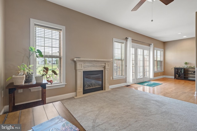 carpeted living area featuring a ceiling fan, baseboards, recessed lighting, and a high end fireplace