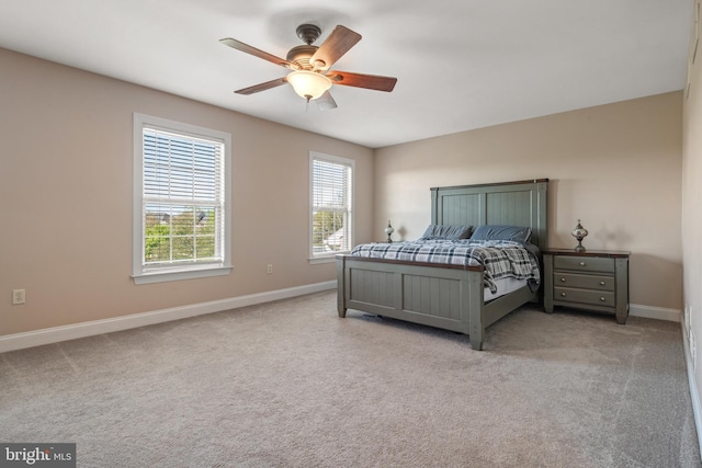 bedroom featuring baseboards, a ceiling fan, and light colored carpet