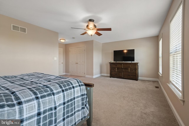 bedroom with ceiling fan, carpet floors, baseboards, visible vents, and a closet