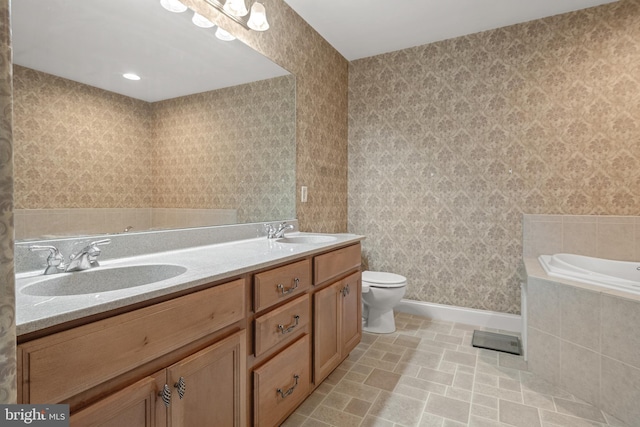 bathroom with toilet, baseboards, a sink, and a garden tub