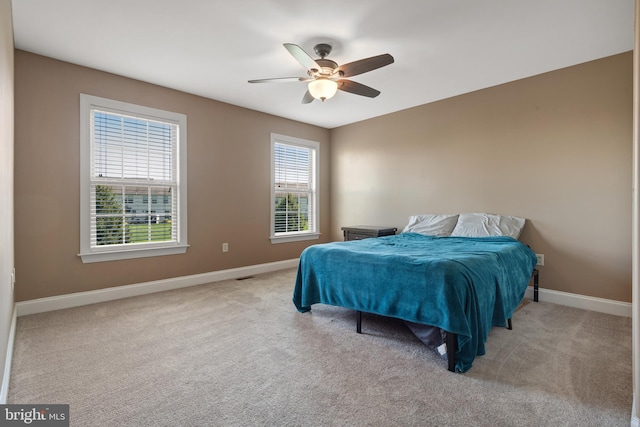 carpeted bedroom featuring baseboards and a ceiling fan