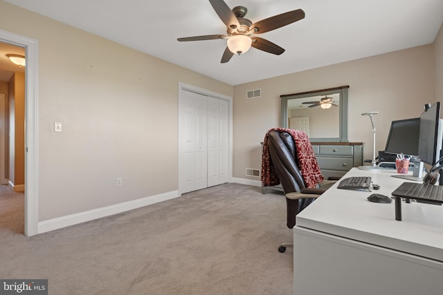 office space with ceiling fan, visible vents, light carpet, and baseboards
