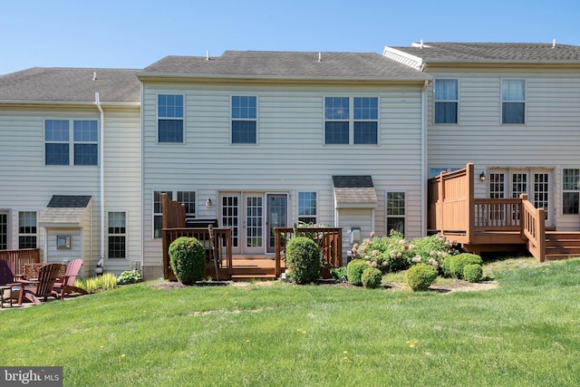 rear view of house featuring a lawn and a deck