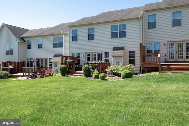 rear view of house with a lawn and a deck
