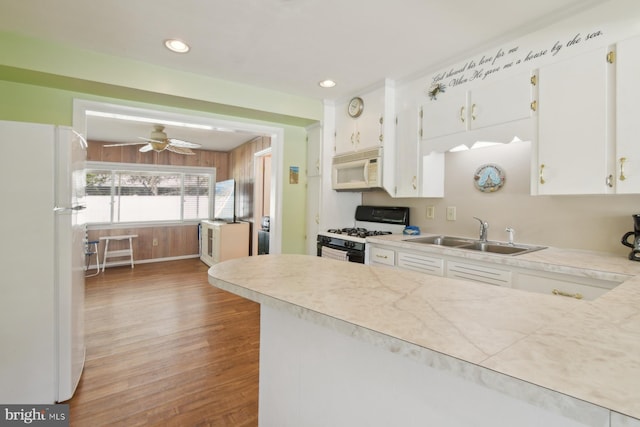9007 Coastal Hwy, Ocean City, MD 21842 - kitchen featuring light wood-type flooring, white appliances, a sink, and white cabinetry