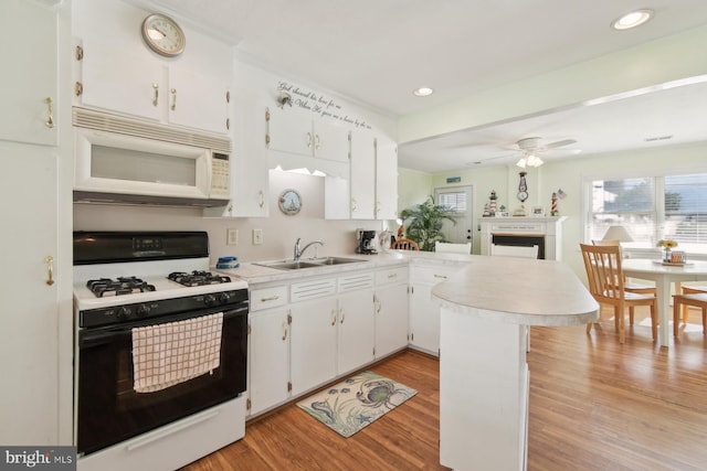 9007 Coastal Hwy, Ocean City, MD 21842 - kitchen with range with gas stovetop, a sink, ceiling fan, white microwave, and a peninsula