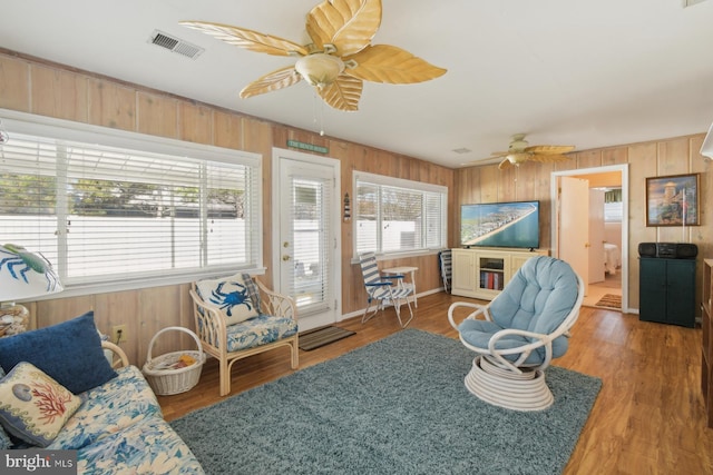 9007 Coastal Hwy, Ocean City, MD 21842 - living area featuring wood walls, a ceiling fan, visible vents, and wood finished floors