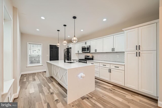 3014 Oakford Ave, Baltimore, MD 21215 - kitchen featuring appliances with stainless steel finishes, light wood finished floors, tasteful backsplash, white cabinetry, and recessed lighting