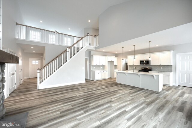 146 Wyndale Dr, Ephrata, PA 17522 - unfurnished living room with recessed lighting, light wood-type flooring, a towering ceiling, and a sink