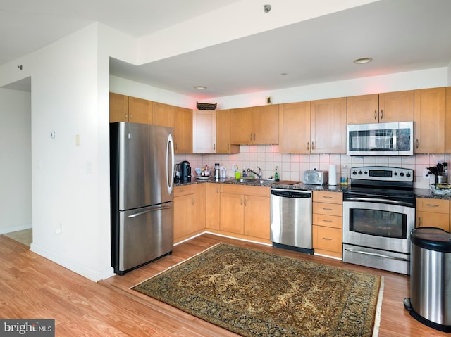 901 N Penn St Unit P506, Philadelphia, PA 19123 - kitchen featuring light wood-style floors, a sink, backsplash, and stainless steel appliances
