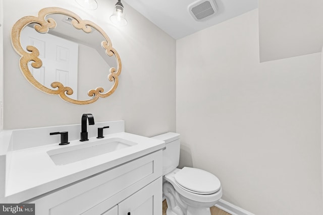 bathroom with vanity, toilet, and visible vents