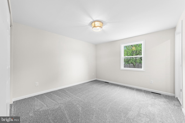 carpeted empty room with baseboards and visible vents