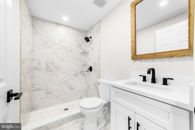bathroom featuring toilet, marble finish floor, tiled shower, and visible vents