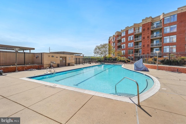 community pool featuring fence and a patio