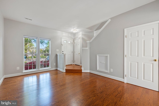 unfurnished living room with baseboards, wood finished floors, and visible vents
