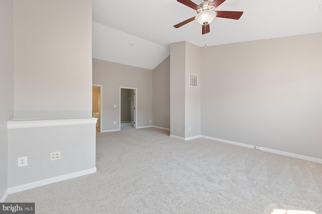 carpeted empty room with visible vents, a ceiling fan, baseboards, and vaulted ceiling