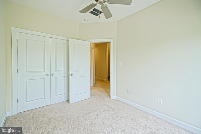 unfurnished bedroom with ceiling fan, light colored carpet, baseboards, visible vents, and a closet