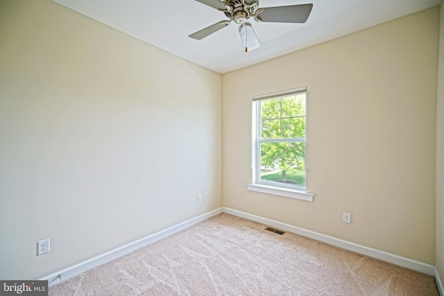 carpeted empty room featuring baseboards, a ceiling fan, and visible vents