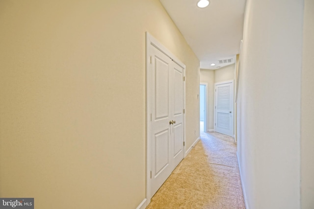 hall featuring visible vents, recessed lighting, baseboards, and light carpet