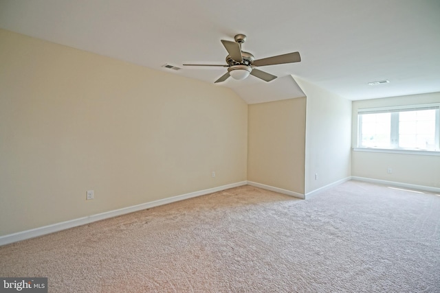 spare room featuring a ceiling fan, baseboards, visible vents, and light carpet