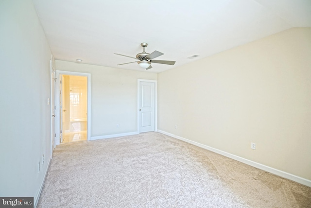carpeted spare room featuring baseboards, ceiling fan, and visible vents