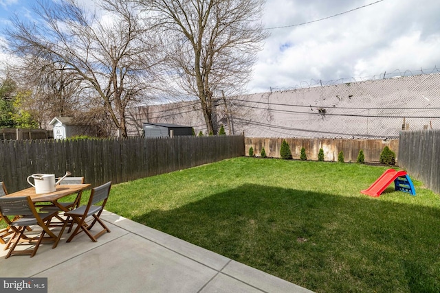 view of yard featuring a fenced backyard, outdoor dining space, and a patio