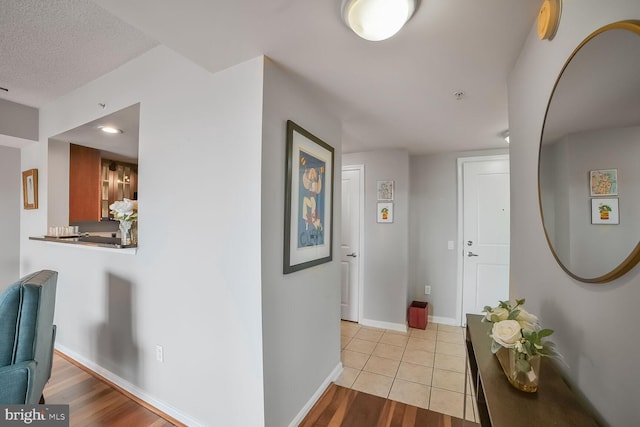 corridor featuring baseboards and light wood-type flooring