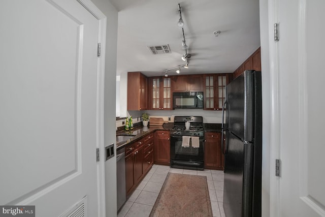 kitchen with black appliances, light tile patterned floors, glass insert cabinets, and dark stone counters