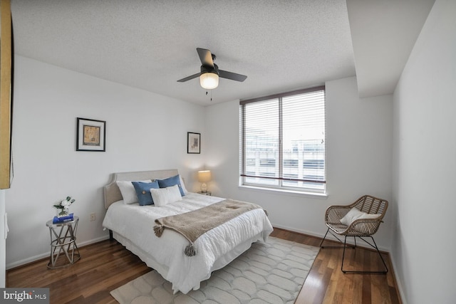 bedroom featuring wood finished floors, baseboards, a textured ceiling, and ceiling fan