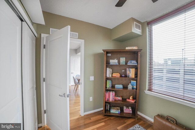 sitting room featuring wood finished floors, baseboards, and ceiling fan