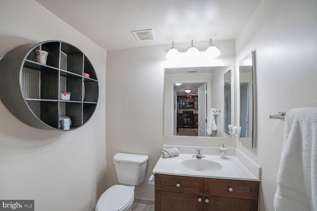 bathroom featuring toilet and vanity