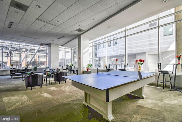 recreation room with carpet flooring, visible vents, and a healthy amount of sunlight