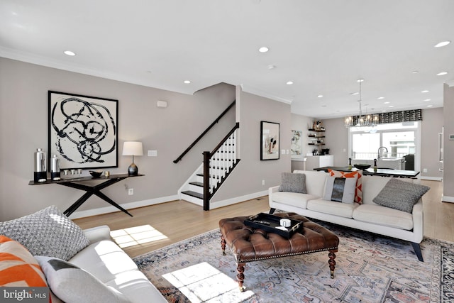 living area with light wood-style floors, recessed lighting, stairway, and a notable chandelier