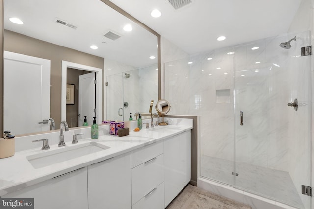 bathroom with a sink, visible vents, and a marble finish shower