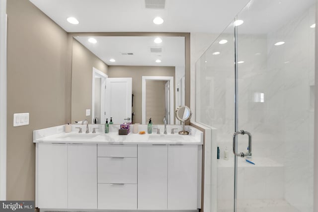 full bath featuring double vanity, visible vents, a sink, and a stall shower