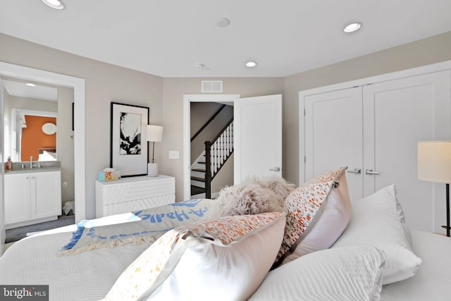 bedroom with a closet, a sink, visible vents, and recessed lighting