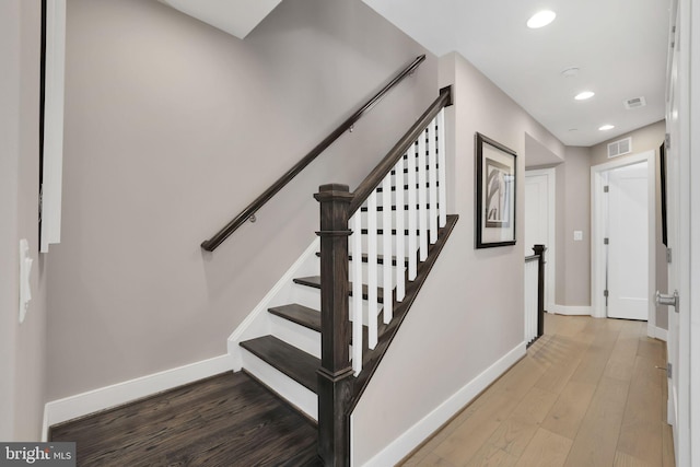 stairway featuring visible vents, baseboards, recessed lighting, and wood finished floors