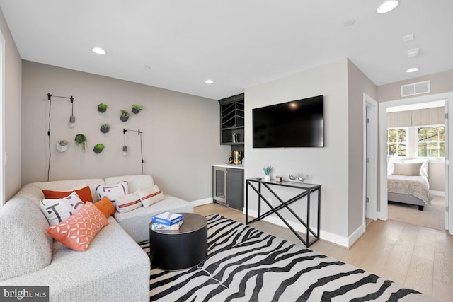 living area featuring recessed lighting, light wood finished floors, visible vents, and baseboards