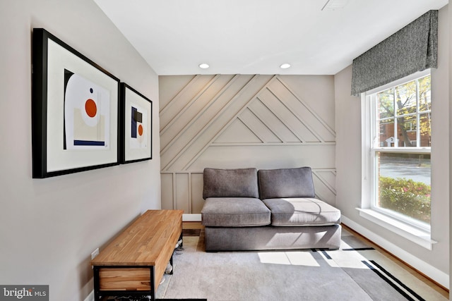 sitting room with baseboards, plenty of natural light, and recessed lighting