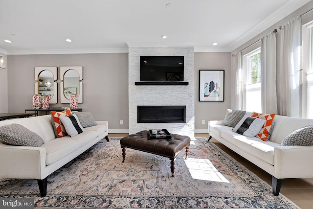 living area featuring baseboards, a stone fireplace, ornamental molding, recessed lighting, and wood finished floors