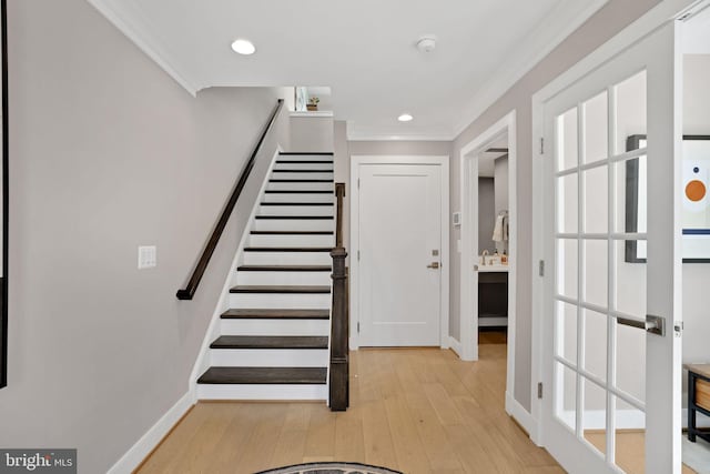 stairway with ornamental molding, baseboards, and hardwood / wood-style flooring