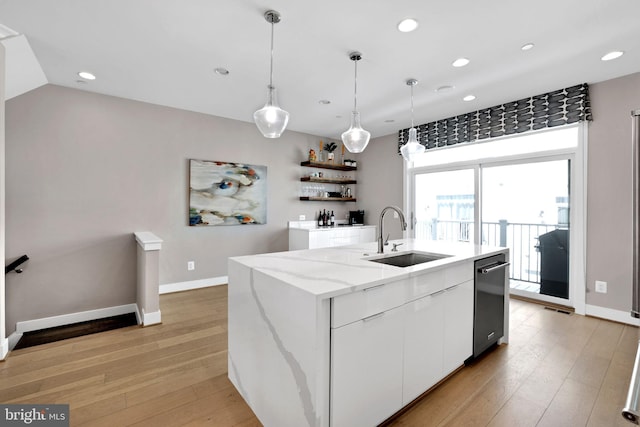 kitchen with recessed lighting, a kitchen island with sink, white cabinetry, and a sink