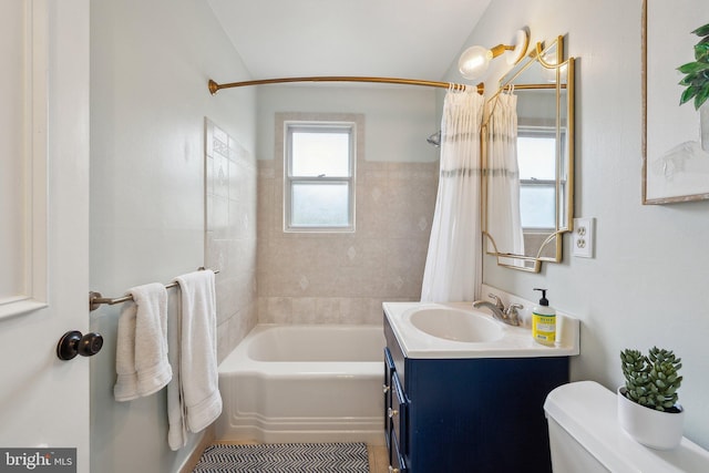 bathroom with shower / bath combo, toilet, vanity, and vaulted ceiling